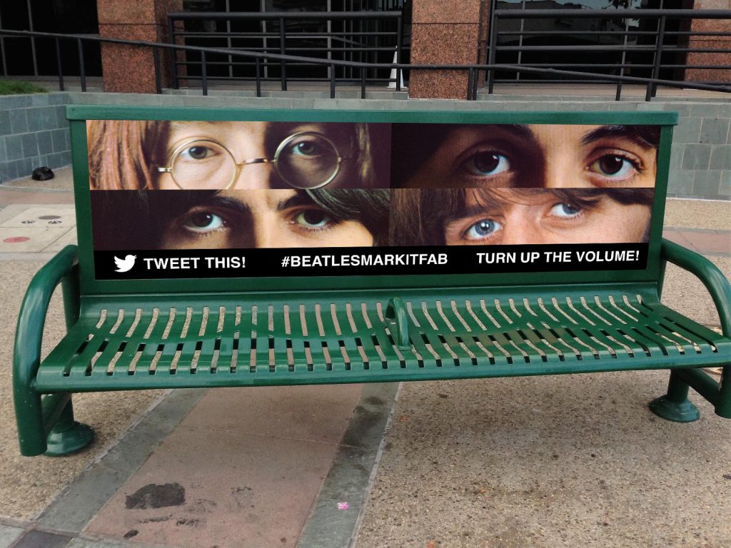 Creative bus bench ad featuring close-up visuals of eyes with bold text and hashtags for enhanced engagement.






